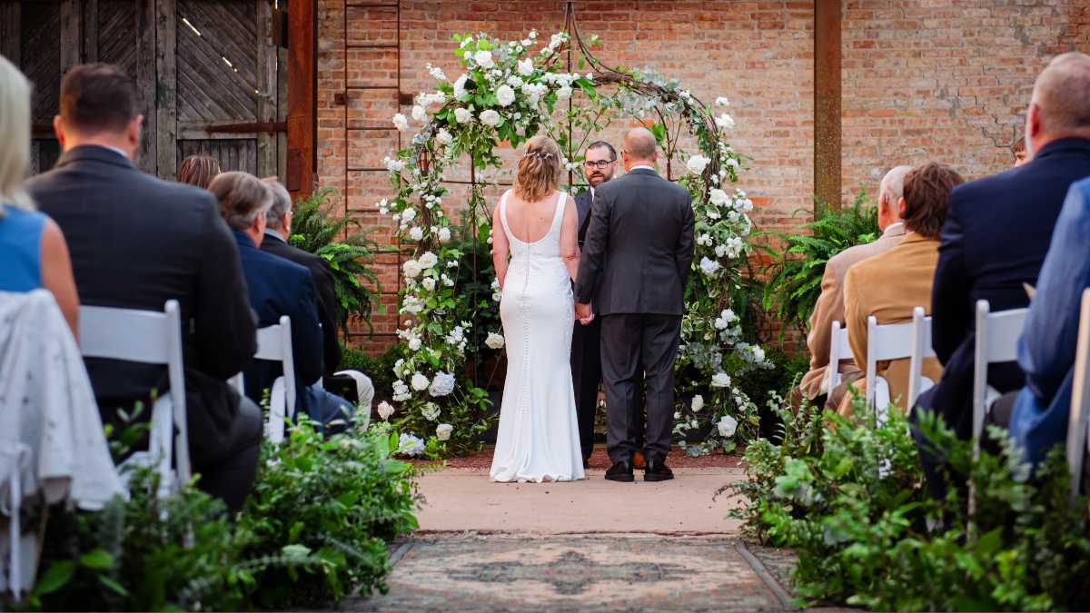 Compact speakers discreetly placed at the sides of a wedding ceremony space away from photographer sight-lines